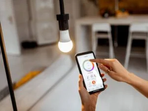 An LED light bulb with a smartphone used to control its warm color temperature through an app.